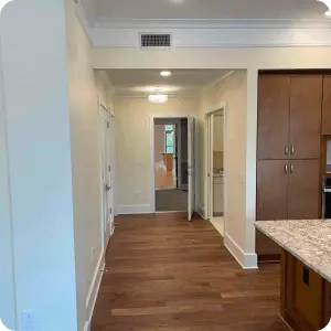 An empty kitchen and living room in a house showcasing quality woodwork and triming